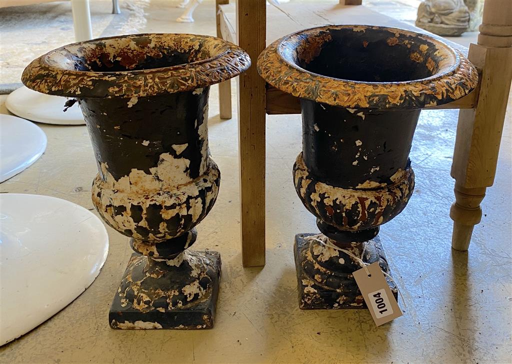 A pair of Victorian cast iron campana shaped garden urns, height 32cm